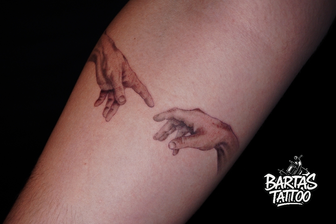 Fine line hands tattoo on a forearm