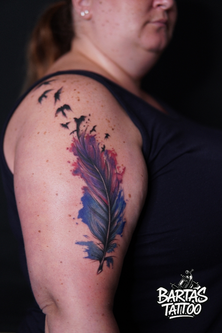 Watercolour feather with birds tattoo on an upper arm